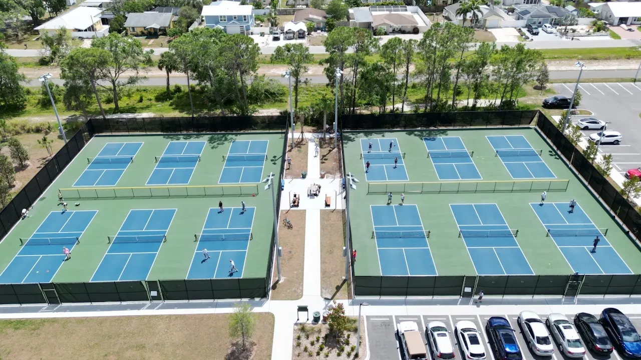 an aerial view of a tennis court and parking lot